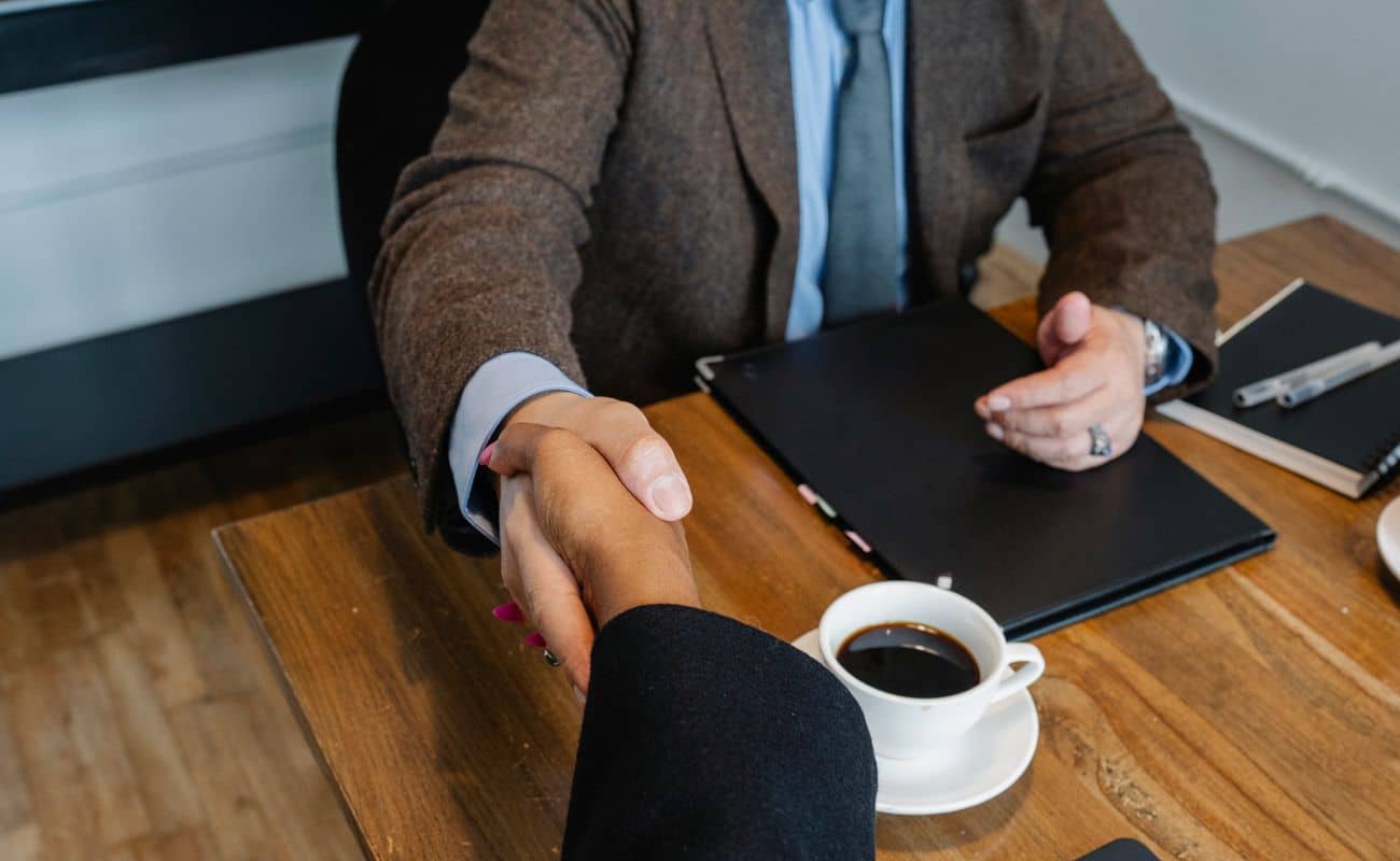 A client and adviser shaking hands across a desk
