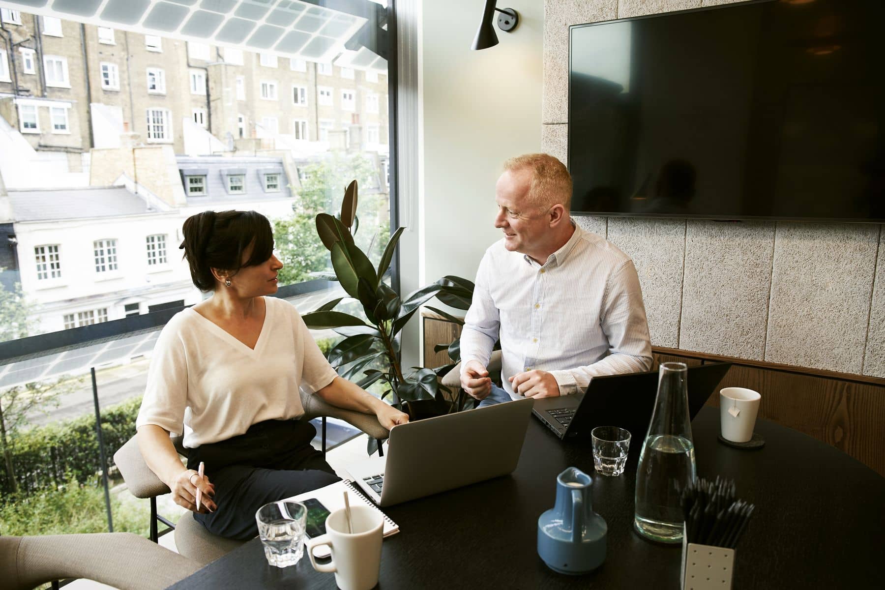 Colleagues in conversation by an office window